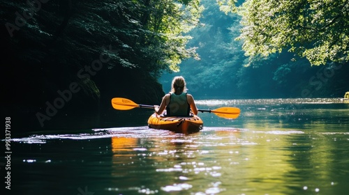 Woman kayaking on a calm lake surrounded by lush greenery.