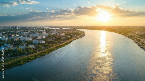 Aerial perspective of a city by the river, with ample space for text in the flowing water and sky