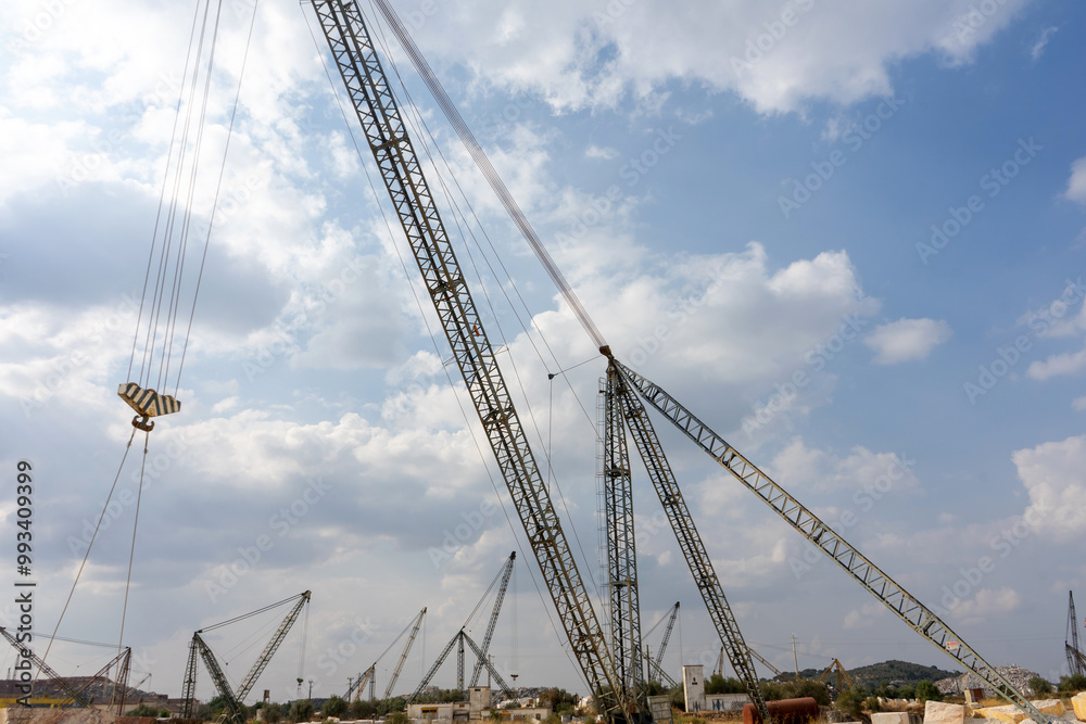 Cranes operate in a marble quarry in Vila Viçosa, Alentejo, showcasing the extraction process of valuable marble, surrounded by stunning natural landscapes. Cranes operate in a marble quarry in Vila Viçosa, Alentejo, showcasing the extraction process of valuable marble, surrounded by stunning natural landscapes.