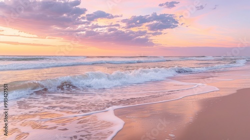 A peaceful beach at sunrise, where gentle waves meet the shore under a sky of pink, orange, and purple hues.
