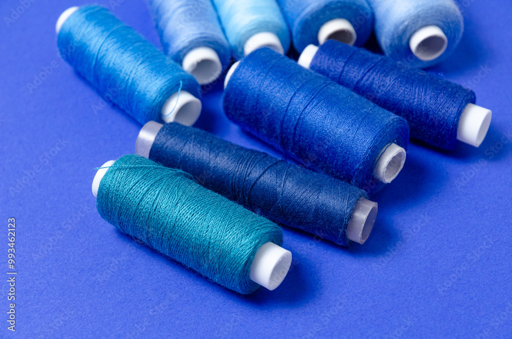 Top view of thread spools on blue background Top view of thread spools on blue background