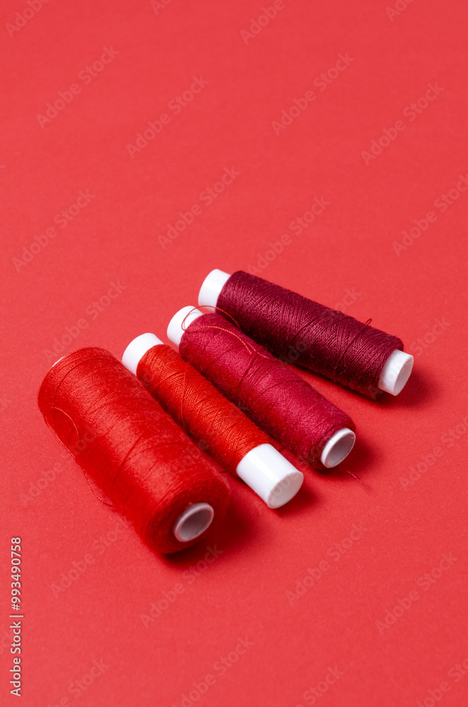 Top view of thread spools on red background Top view of thread spools on red background