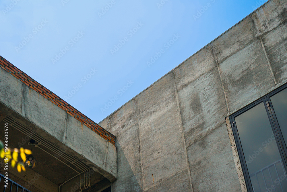 The architectural detail of a roofline on a home. Rusty roof of old building against blue sky. view from below of old building with sky background The architectural detail of a roofline on a home. Rusty roof of old building against blue sky. view from below of old building with sky background