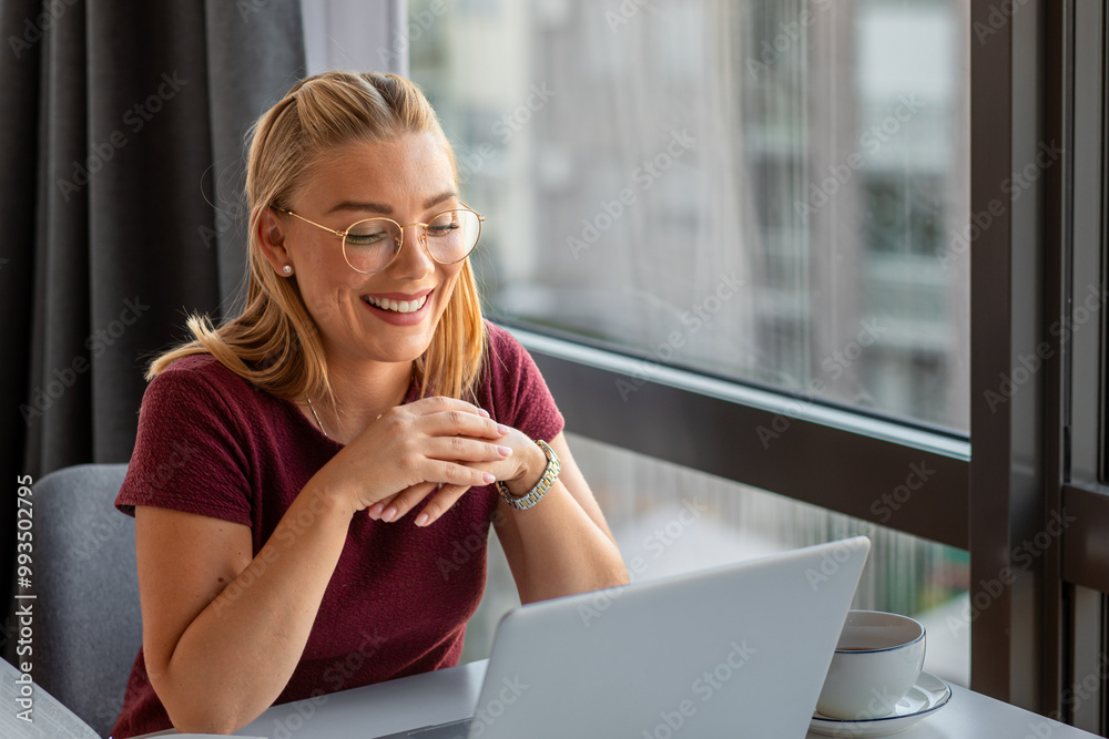 Smiling woman sitting in office working using laptop. Smiling woman sitting in office working using laptop.