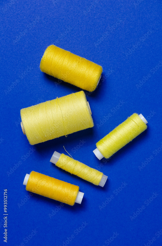Top view of yellow thread spools on blue background Top view of yellow thread spools on blue background