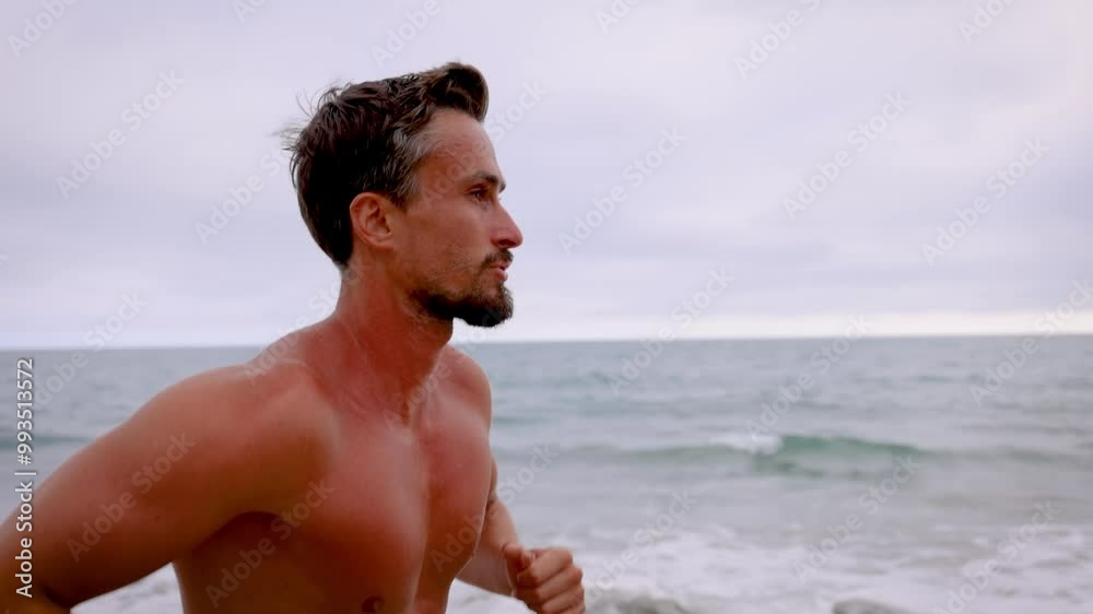 Athletic man jogging at the beach in Southern California. Slow Motion.