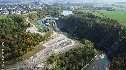 Aerial approach with a drone of the fall of the hydroelectric dam of the Mitis power station, on the Mitis Salmon River with the village of Price in the background. photo