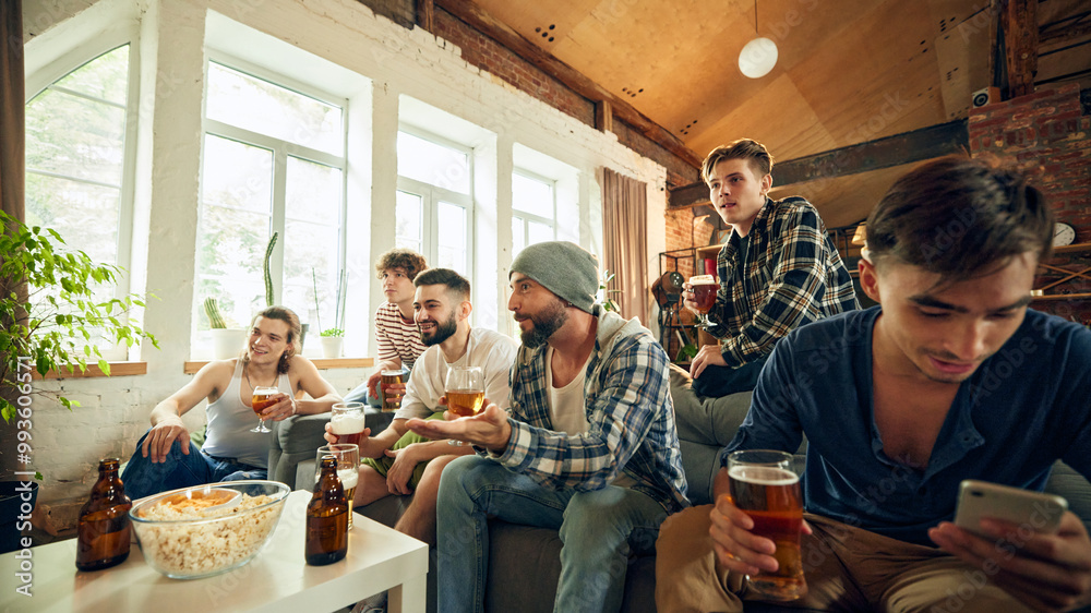 Obraz premium Tension high as everyone focuses on screen, holds beer in hand. Competition is fierce, but fun even greater. Togetherness. Concept of football fans, sport evens, video games and cybersport.