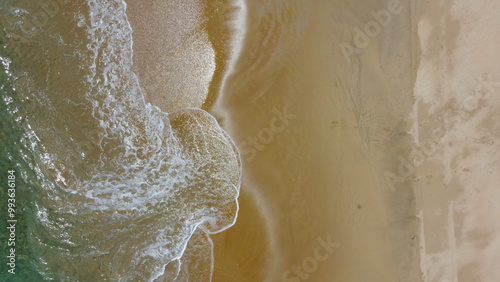Bilde på lerret Drone point of view, directly down, turquoise colored sea waves breaking onto white beach sand