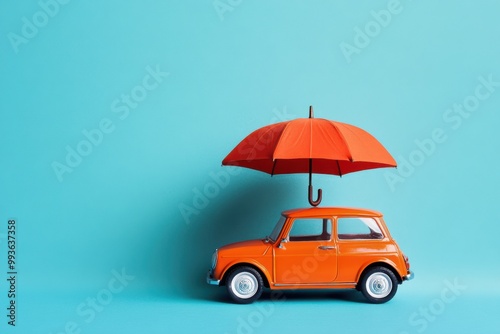 A playful design featuring a toy car sheltered under an open umbrella against a blue background. Insurance and protection concept photo