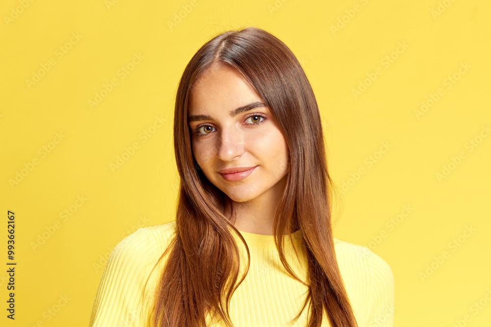 Close up portrait of young beautiful girl, student looking with warm, light smile at camera against bright yellow background. Concept of human emotions, business, beauty and fashion, sales season. Ad Close up portrait of young beautiful girl, student looking with warm, light smile at camera against bright yellow background. Concept of human emotions, business, beauty and fashion, sales season. Ad