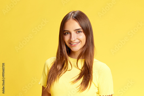 Young beautiful girl, student looking with bright smile at camera against bright yellow background. Positive people. Concept of human emotions, business, beauty and fashion, sales season. Ad