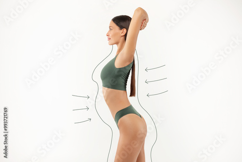 Weight loss concept. Lady in underwear with drawn silhouette around her body, woman with sporty figure enjoying slimming result, side view photo