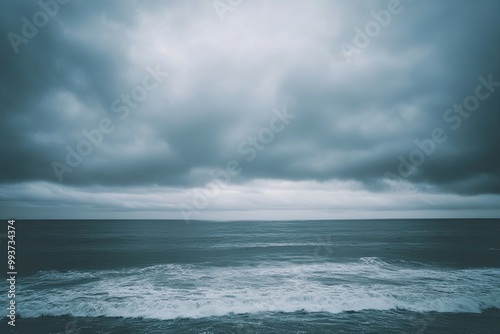 Overcast sky with thick, grey clouds covering the entire horizon, creating a moody and calm atmosphere