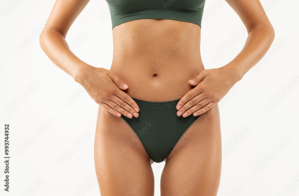 Slim skinny woman in green underwear holding hands, gesturing pain in intimate zone, white background. Maternity fertilization disease infertility concept Slim skinny woman in green underwear holding hands, gesturing pain in intimate zone, white background. Maternity fertilization disease infertility concept