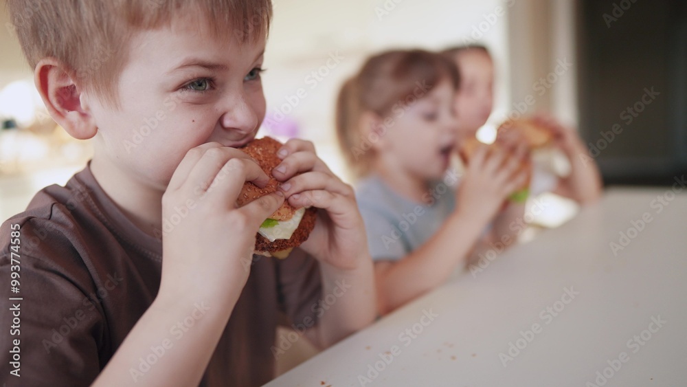 children eat burgers. fast food burger. a group of small children in the kitchen greedily eat fast food fun burgers. big family small kids having breakfast in the morning in the kitchen eating burger children eat burgers. fast food burger. a group of small children in the kitchen greedily eat fast food fun burgers. big family small kids having breakfast in the morning in the kitchen eating burger