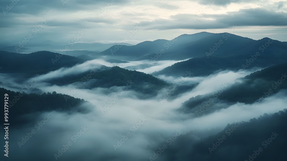 Misty mountain landscape with low hanging clouds drifting over the peaks and valleys creating a serene and mysterious atmosphere The layers of fog envelop the scenery Misty mountain landscape with low hanging clouds drifting over the peaks and valleys creating a serene and mysterious atmosphere The layers of fog envelop the scenery