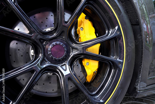 Alloy wheel with calipers and racing brakes of the sport car. Racing brake disc and low profile tyres. Race car test driving. Lower-profile tires of drag and drift cars. High-performance sports cars.