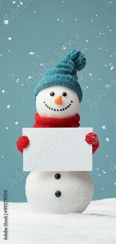 Snowman holding a blank sign, snowy winter background. photo