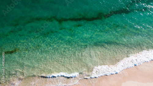 Aerial view of the beautiful turquoise sea with algae in Comporta, Portugal