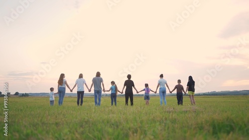 large group of people holding hands. family big community outdoors in the park holding hands together. happy family kid dream concept. people support each other joined hands nature lifestyle back view