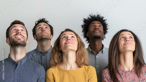 Diverse group of adults looking upwards with curiosity and wonder, indoors