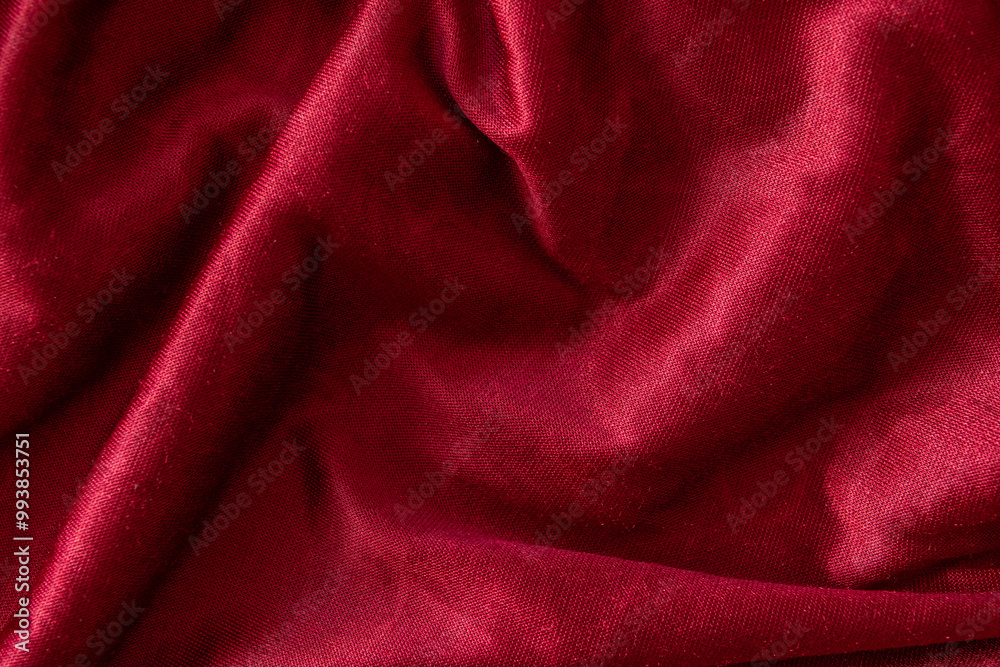 Fototapeta premium Red velvet textile folded fabric for background. Top view.