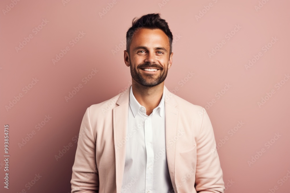 Portrait of a grinning man in his 30s wearing a chic cardigan in front of pastel or soft colors background
