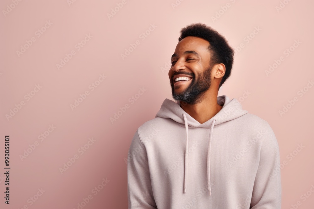 Portrait of a blissful man in his 30s sporting a comfortable hoodie while standing against pastel or soft colors background Portrait of a blissful man in his 30s sporting a comfortable hoodie while standing against pastel or soft colors background