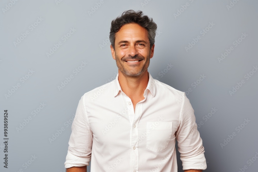 Portrait of a joyful man in his 40s wearing a classic white shirt while standing against pastel or soft colors background Portrait of a joyful man in his 40s wearing a classic white shirt while standing against pastel or soft colors background
