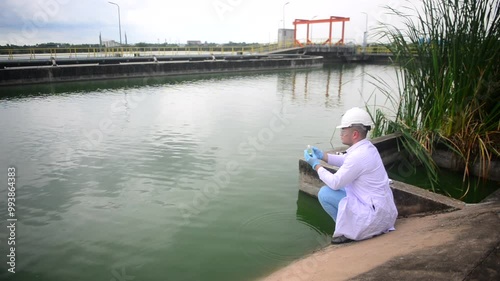 Scientist Ecologist taking a water sample in a beaker glass and use TDS EC meter to reading ph value at waste water treatment 