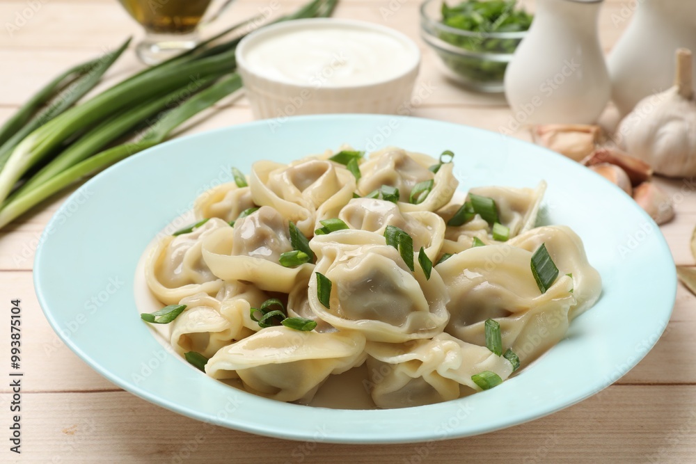 Delicious pelmeni with green onion served on white wooden table, closeup Delicious pelmeni with green onion served on white wooden table, closeup
