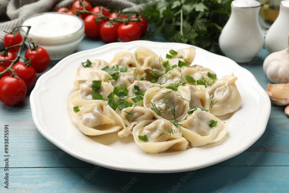 Delicious pelmeni with green onion served on blue wooden table Delicious pelmeni with green onion served on blue wooden table