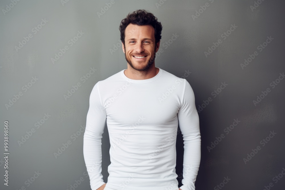 Portrait of a happy man in his 30s sporting a long-sleeved thermal undershirt over minimalist or empty room background Portrait of a happy man in his 30s sporting a long-sleeved thermal undershirt over minimalist or empty room background