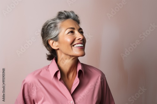 Portrait of a joyful woman in her 50s sporting a breathable hiking shirt isolated in minimalist or empty room background photo