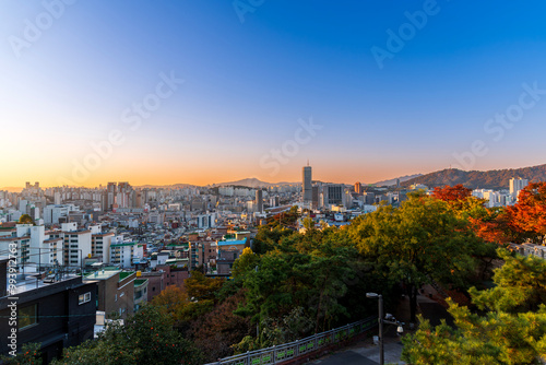 Obraz na płótnie Sunset of Seoul cityscape with high rise office buildings and skyscrapers and cityFortress wall of Heunginjimun with autumn colorful park, Seoul, South Korea in autumn season w salonie