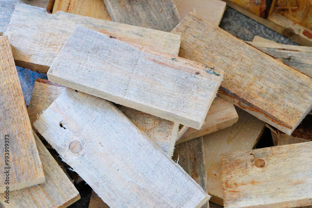 A collection of wooden planks is scattered across a surface, showcasing a range of textures and colors. The light enhances the natural grain and imperfections, creating an interesting visual display o A collection of wooden planks is scattered across a surface, showcasing a range of textures and colors. The light enhances the natural grain and imperfections, creating an interesting visual display o