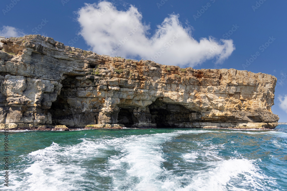 View from the water of picturesque coastline with cliffs and caves by Adriatic Sea, Polignano a Mare, Italy, Apulia