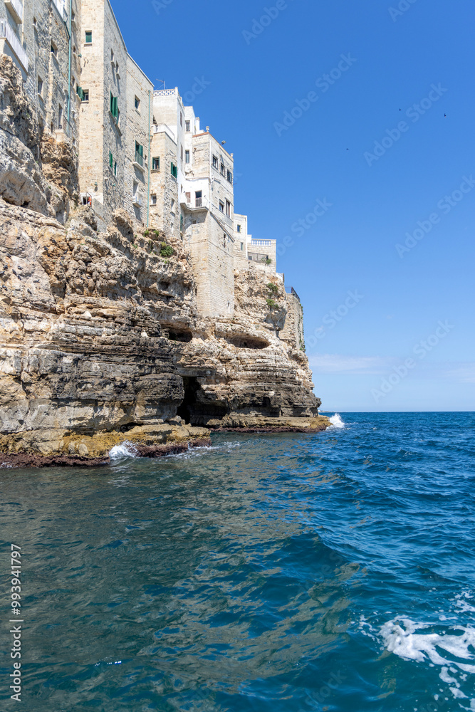 Buildings built on cliffs, view from the sea of picturesque rocks and caves, Polignano a Mare, Italy, Apulia