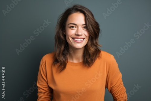 Portrait of a smiling woman in her 30s sporting a long-sleeved thermal undershirt isolated on solid color backdrop