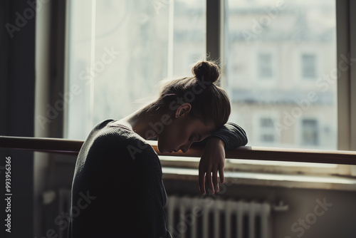 Sad, tired ballerina girl came and stood near the window.