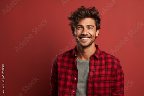 Portrait of a glad man in his 20s wearing a comfy flannel shirt in solid color backdrop