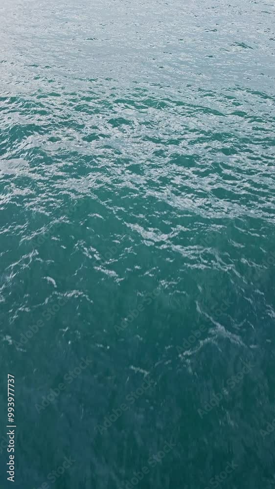 Calm ocean surface in a serene coastal area during midday, showcasing peaceful water and minimal waves Calm ocean surface in a serene coastal area during midday, showcasing peaceful water and minimal waves