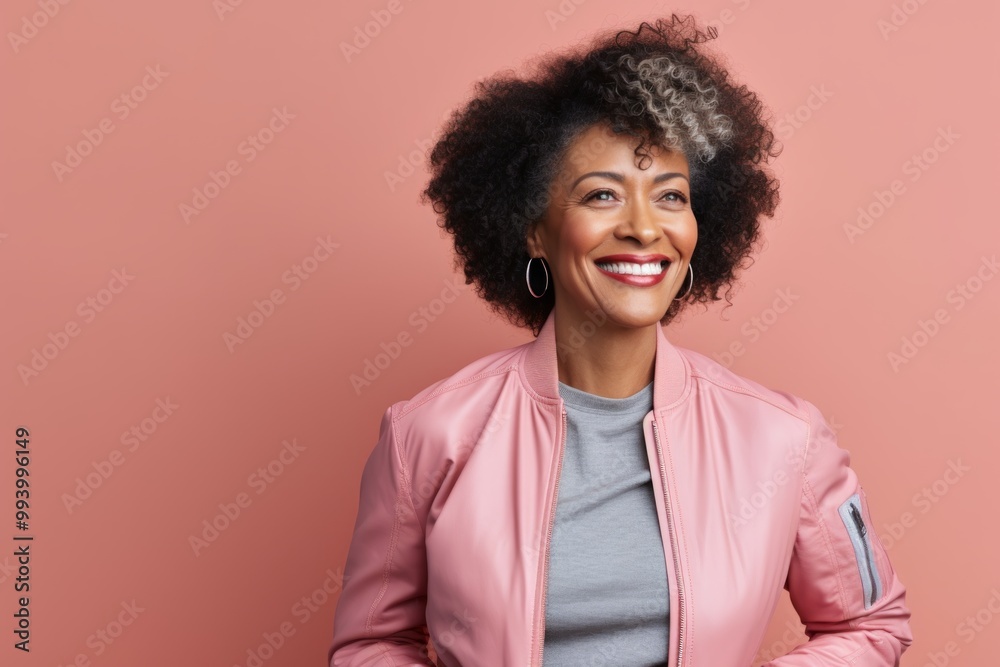 Portrait of a smiling afro-american woman in her 60s sporting a stylish varsity jacket in solid pastel color wall Portrait of a smiling afro-american woman in her 60s sporting a stylish varsity jacket in solid pastel color wall