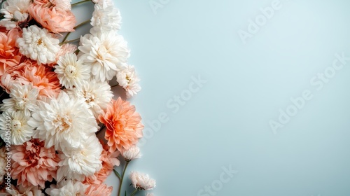 An artistic display of white and orange flowers beautifully arranged, covering half the blue background, perfect for nature-themed designs or as a decorative element. photo