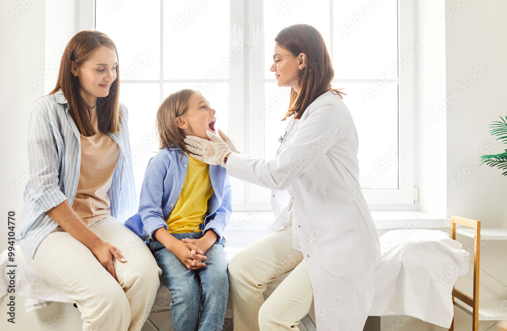 Obraz premium Dentist doctor or nurse conducts an examination on boy patient at the clinic. Boy mother is present during the medical treatment, as the healthcare professional provides dentistry care for the child.