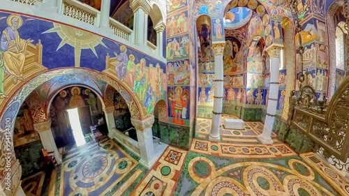 Topola, Serbia, Sept 2,2024: Wide angle view of the interior of the orthodox church of St. George in Topola, Serbia, highlighting the colorful stone floor and religious frescoes on walls and columns photo