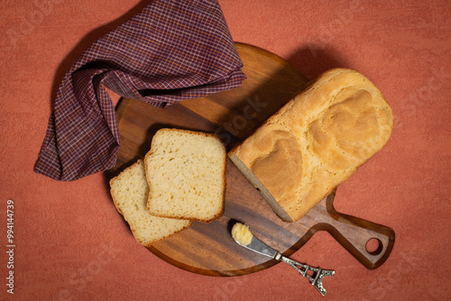 Fresh Baked Homemade Bread with Red Cloth on Orange Background with small butter knife to side