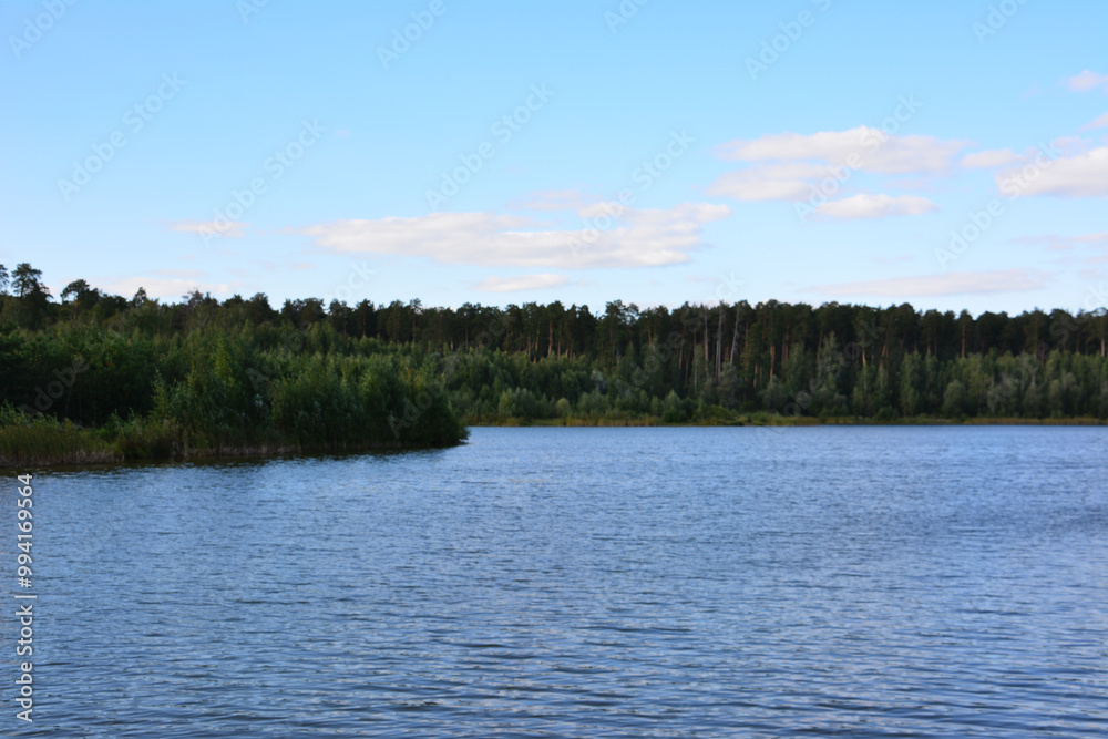 a lake with a forest in the background and a small island in the middle of the water a lake with a forest in the background and a small island in the middle of the water