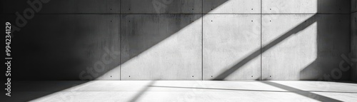 This minimalist concrete wall features subtle texture and shadow play, presenting a sleek and modern background for industrial design elements.